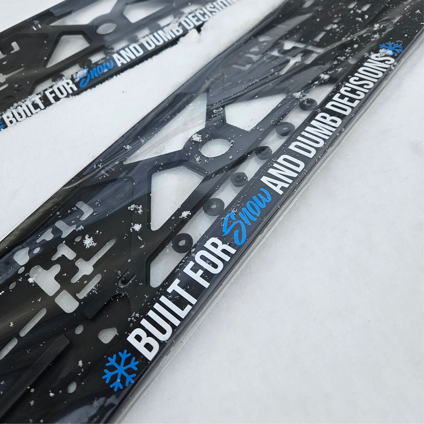 Two black ski frames with 'Built for Snow and Dumb Decisions' text on a white background