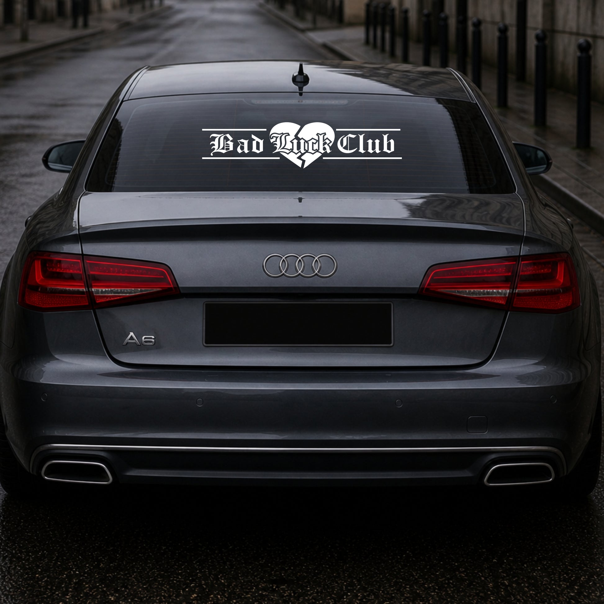 Audi car with 'Bad Luck Club' decal on the back window.
