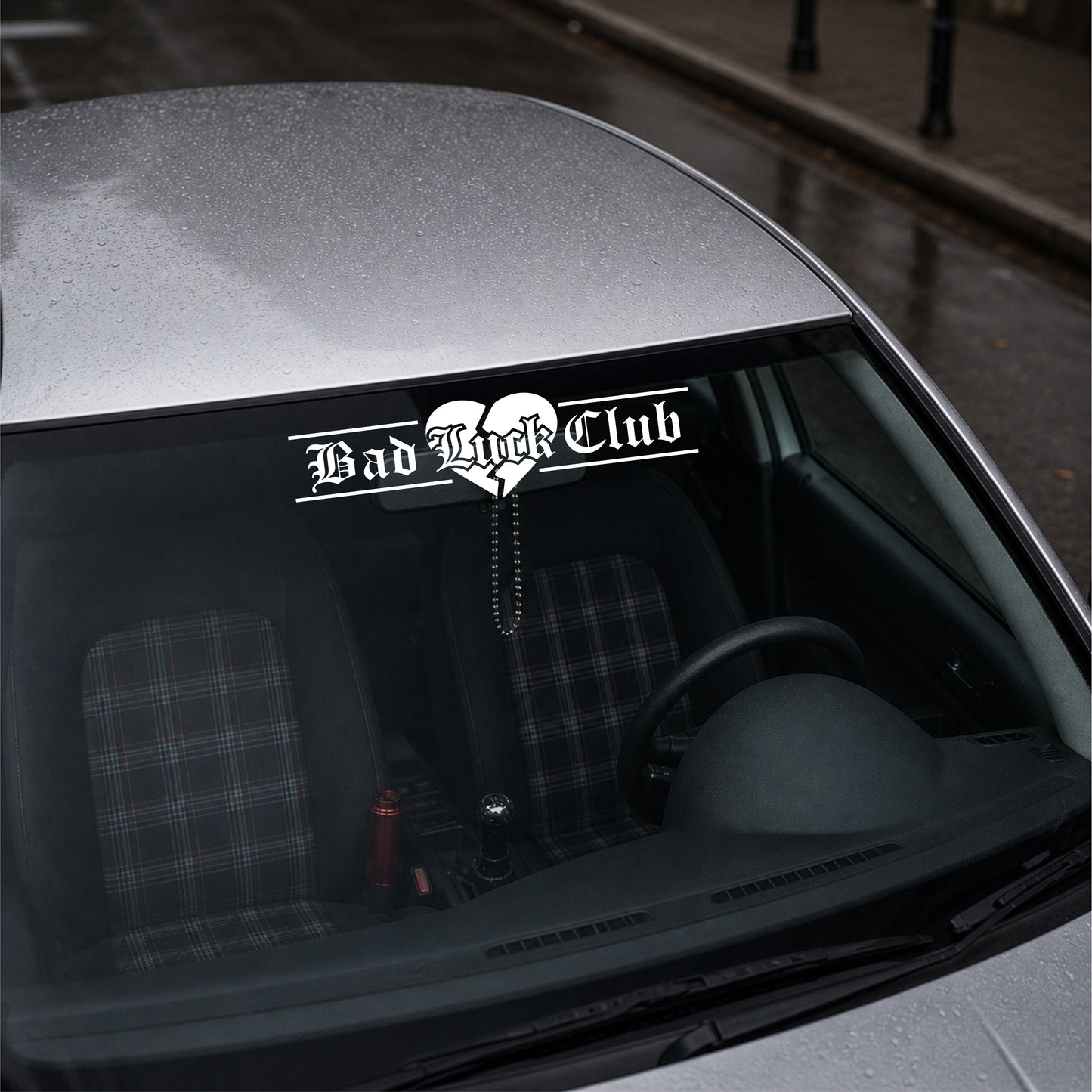 Car with a 'Bad Luck Club' decal on the windshield.