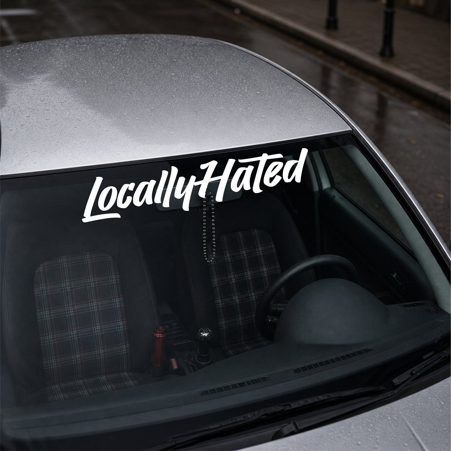 Car with 'Locally Hated' decal on the windshield