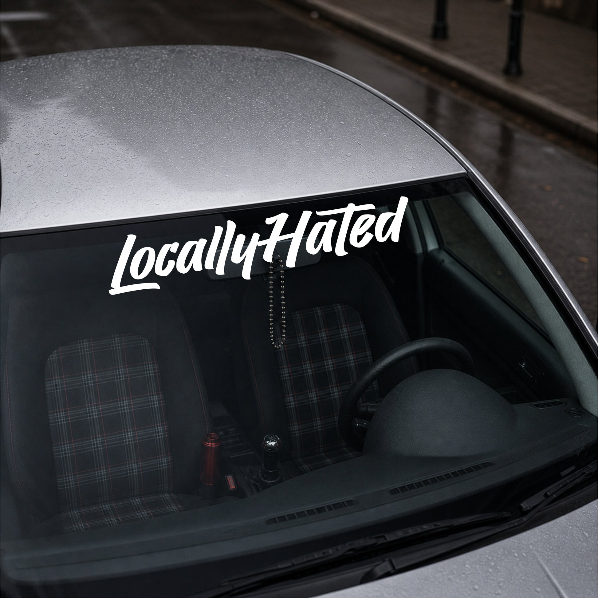 Car with 'Locally Hated' decal on the windshield