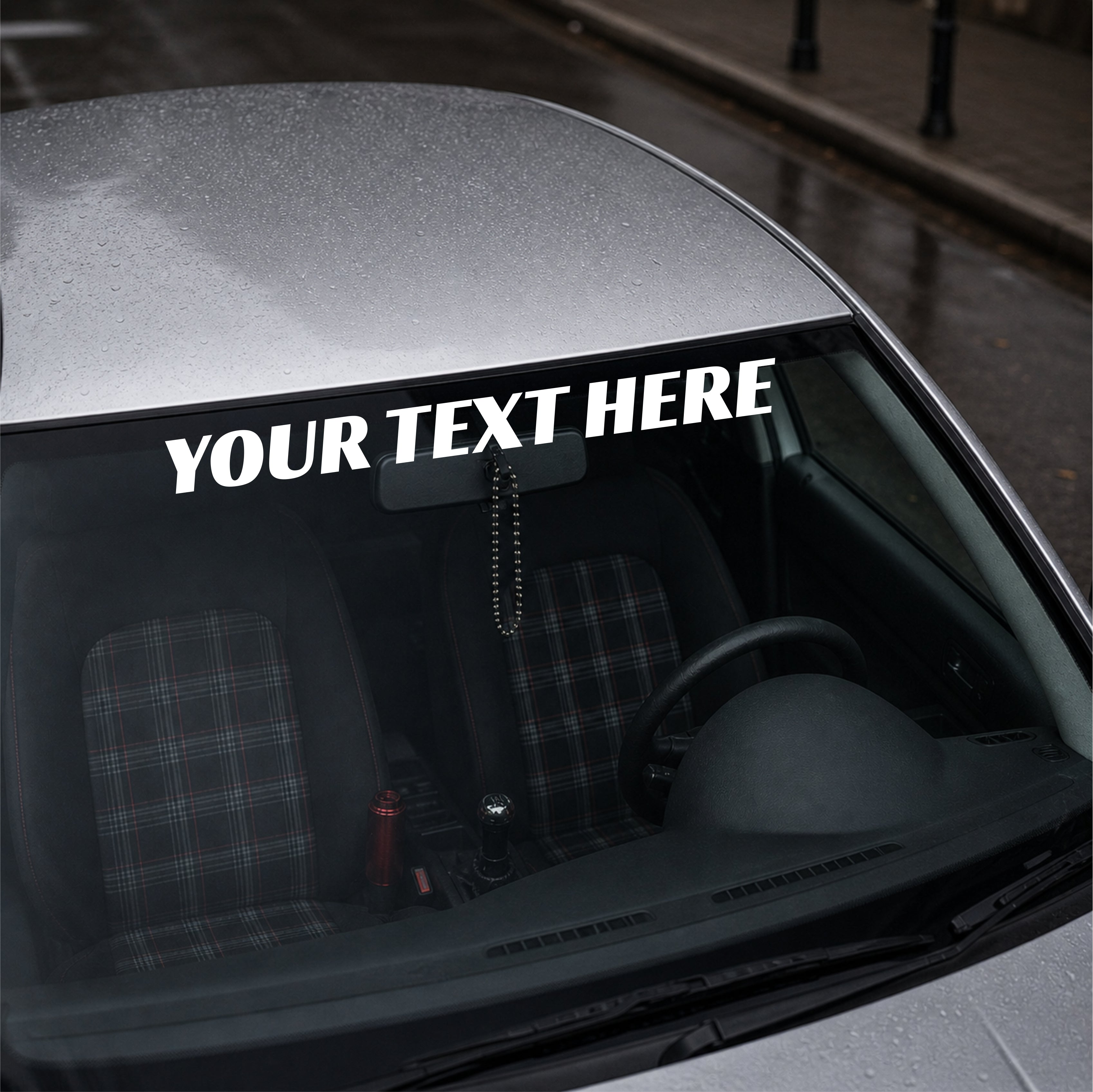 Car interior with a customizable text decal on the windshield.