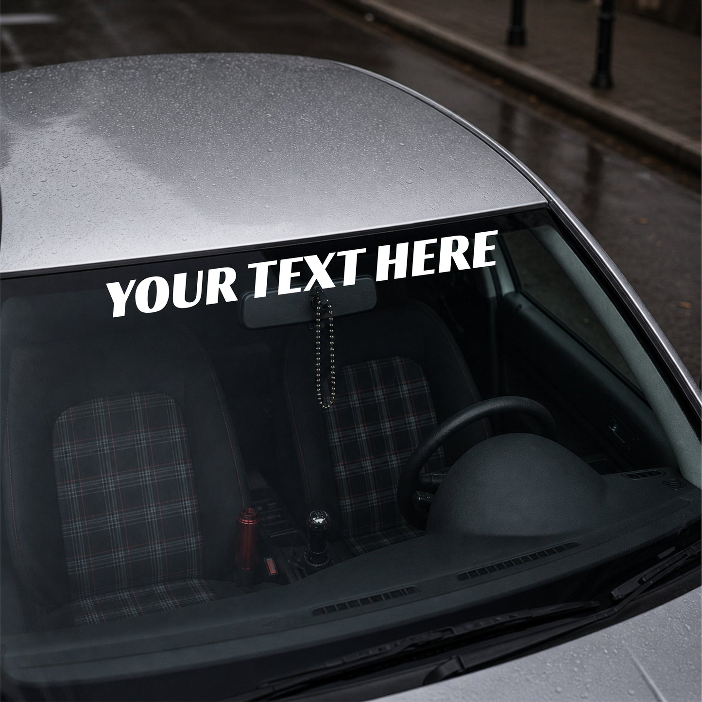 Car interior with a customizable text decal on the windshield.