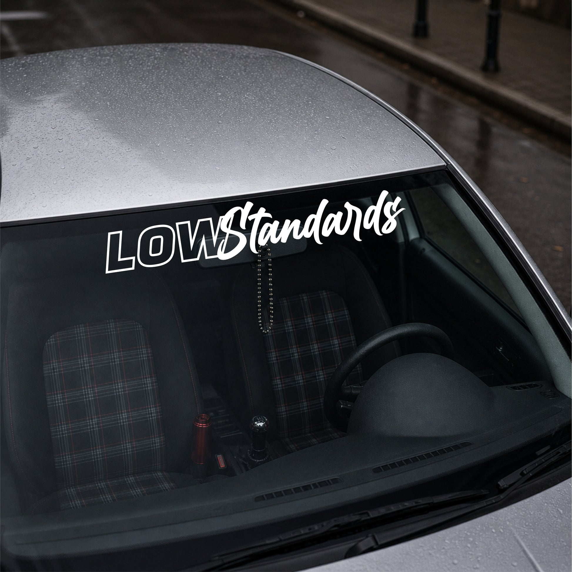 Car with 'LOW Standards' decal on the windshield