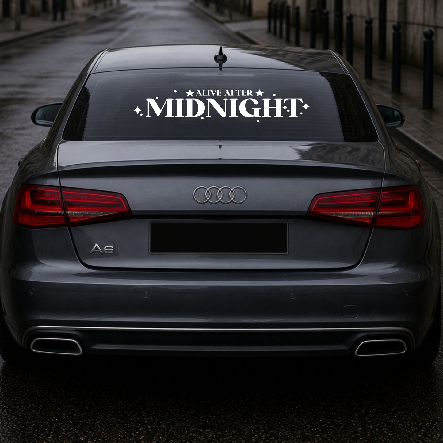 Audi car with 'Alive After Midnight' decal on the back window.