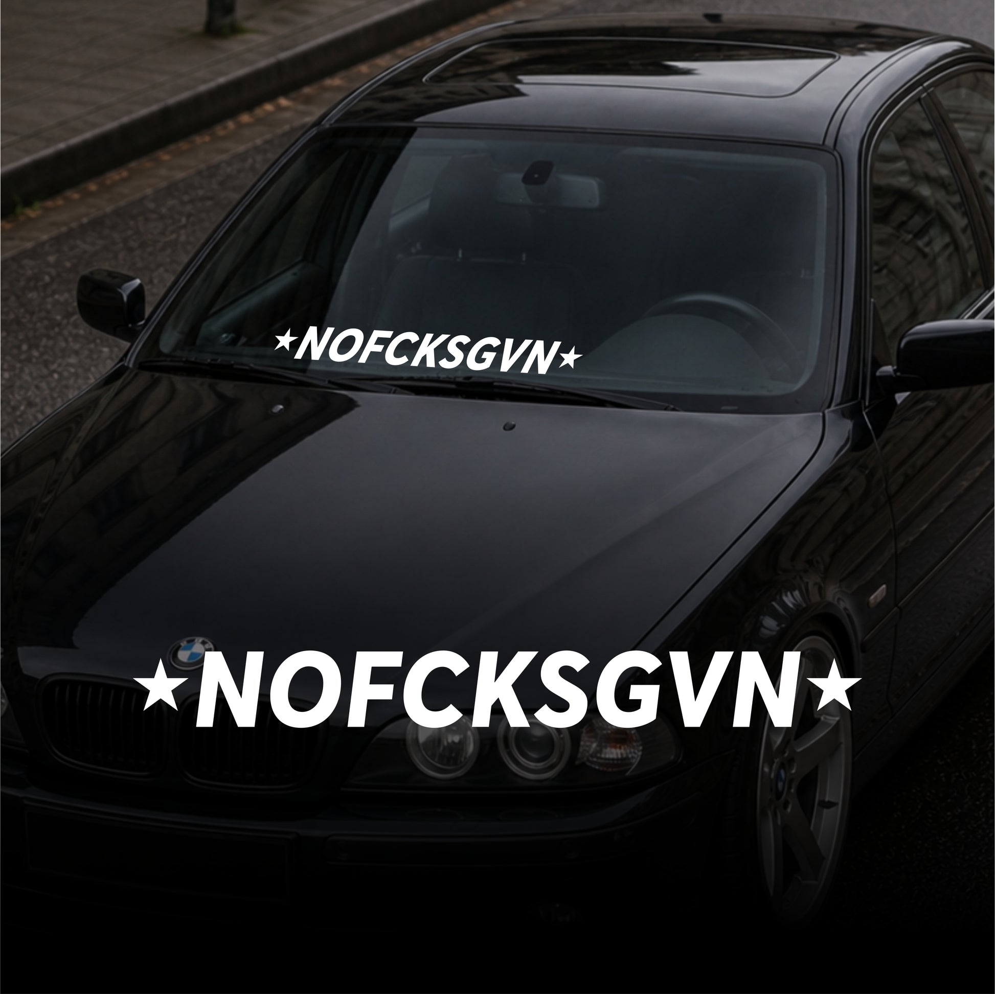 Black car with 'NOFCKSGVN' decal on windshield and front bumper