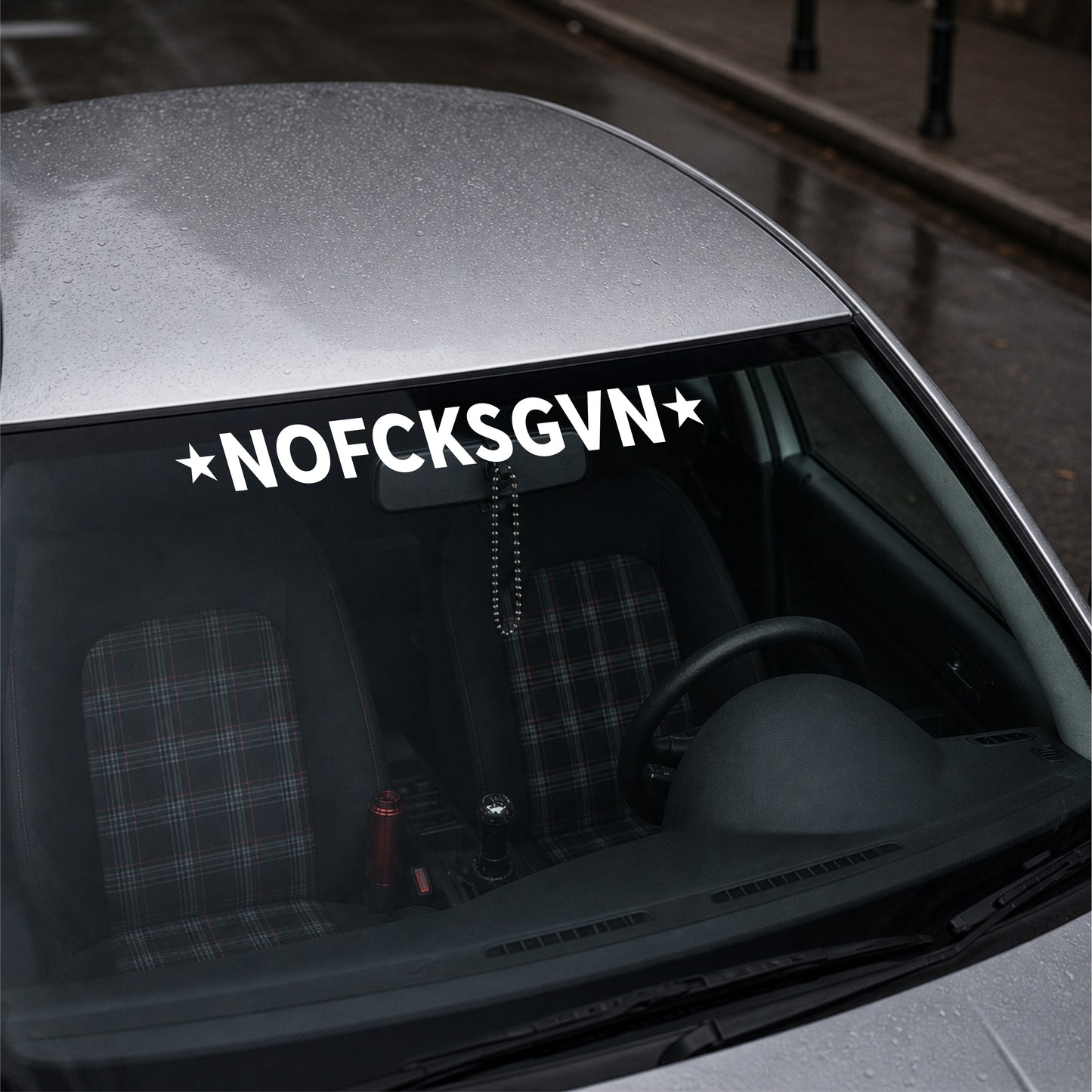 Car with a decal reading 'NOFCKSGVN' on the windshield.