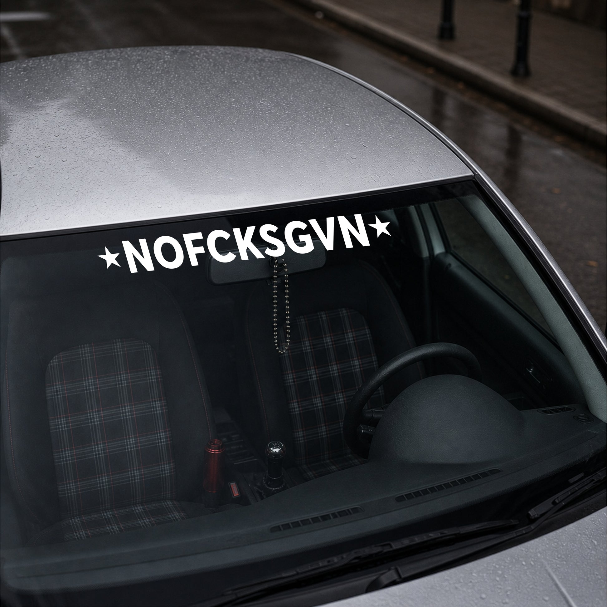Car with a decal reading 'NOFCKSGVN' on the windshield.