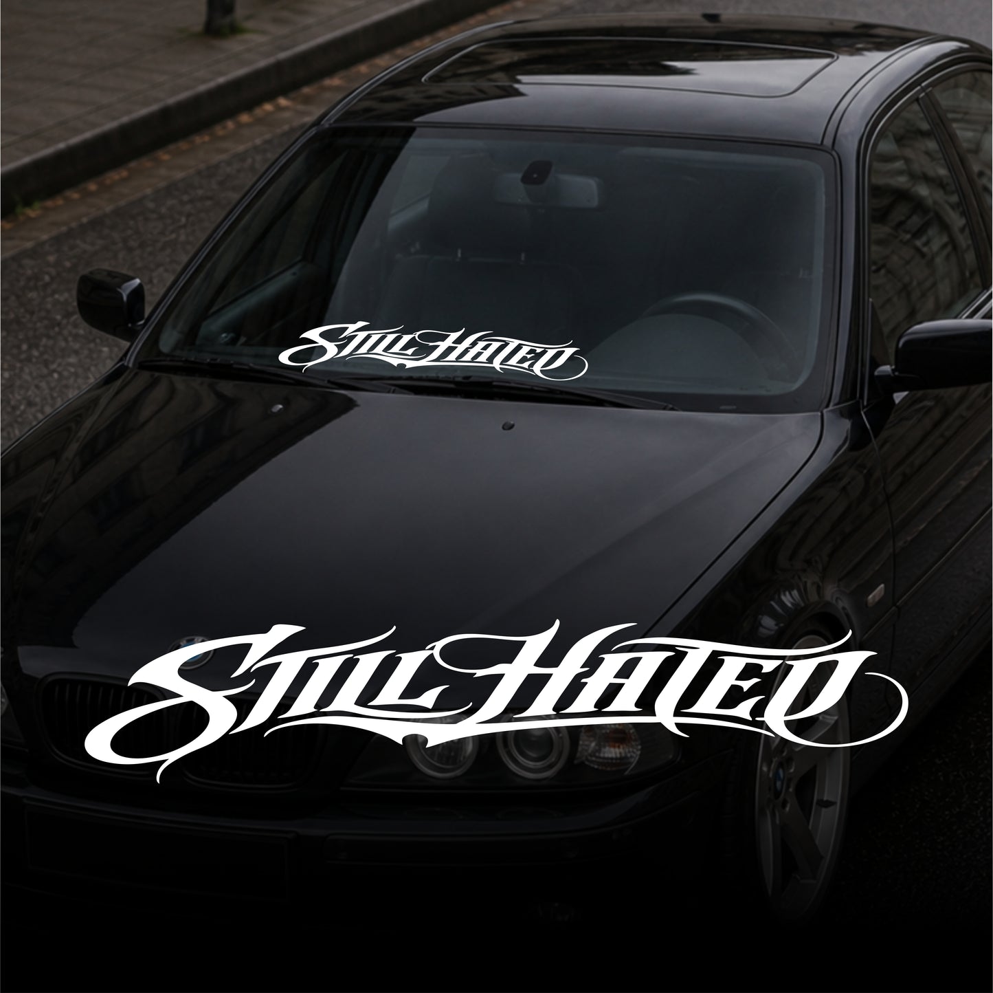 Black car with 'Still Hated' decal on a dark background
