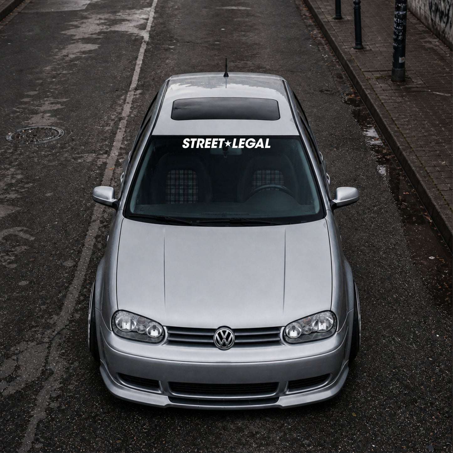 Silver Volkswagen car on a street with 'street legal' decal.
