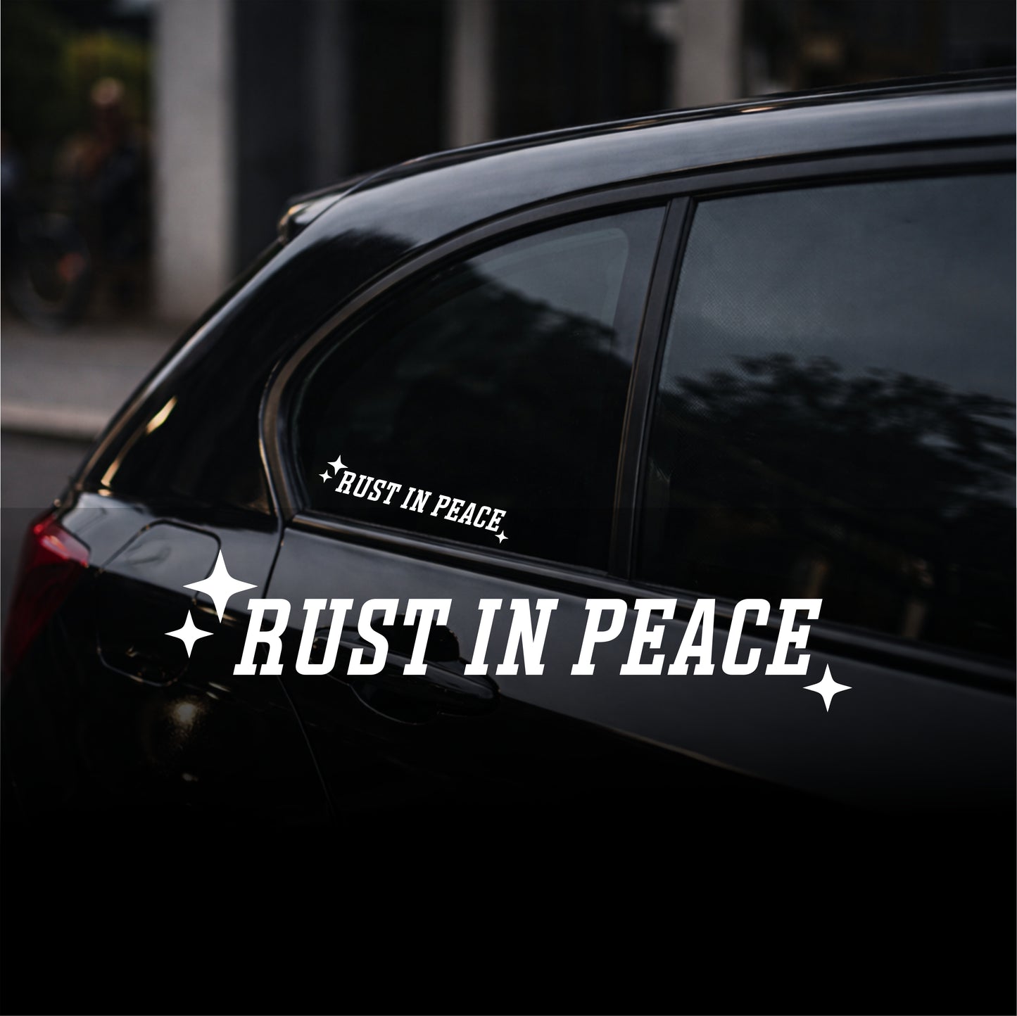 Car with 'Rust in Peace' decal on a dark background