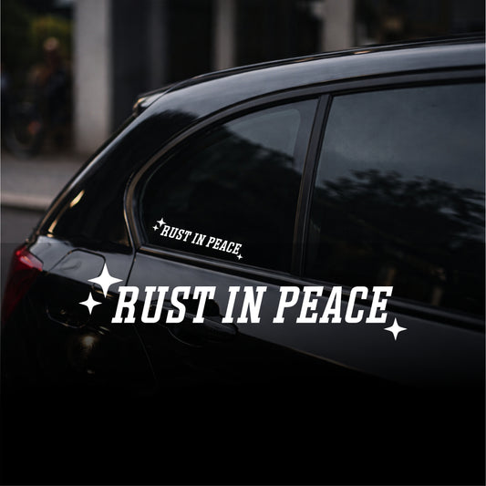 Car with 'Rust in Peace' decal on a dark background