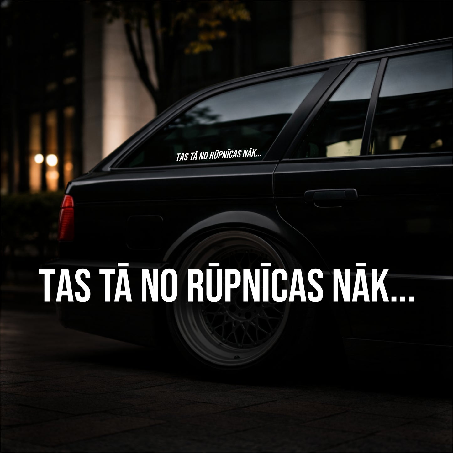 Black car with text on the window and side, set against a dark background.