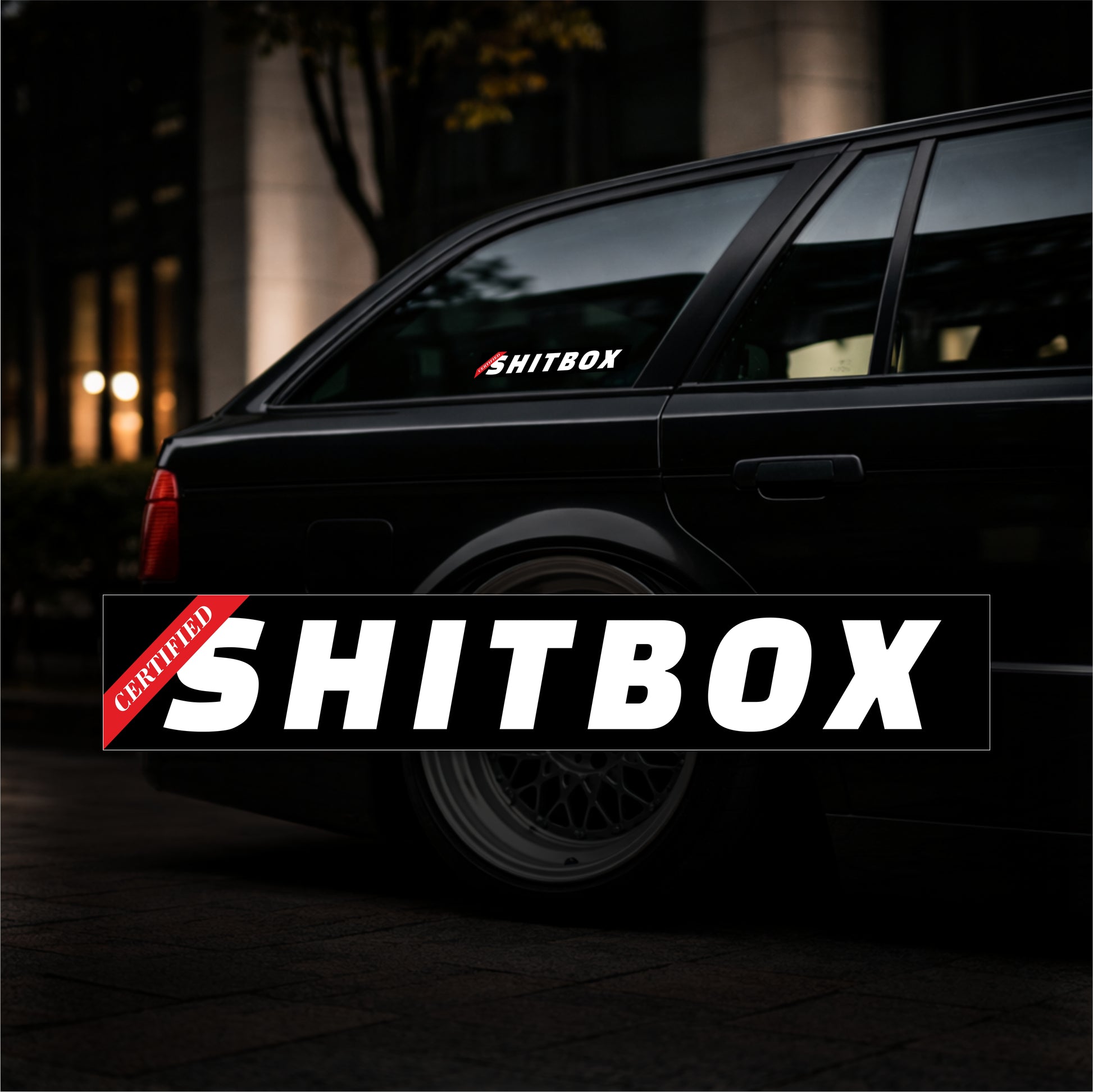 Black car with 'SHITBOX' decal on a dark background