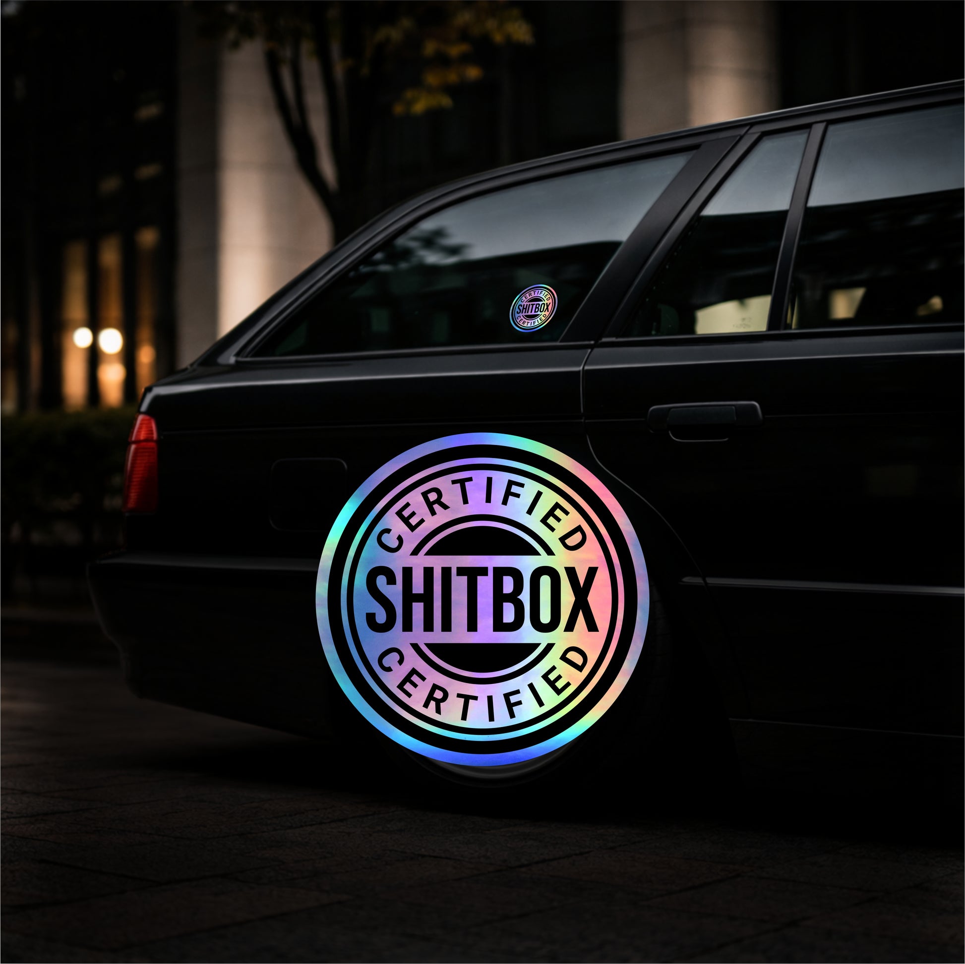 Car with a colorful 'Certified Shitbox' sticker on the back