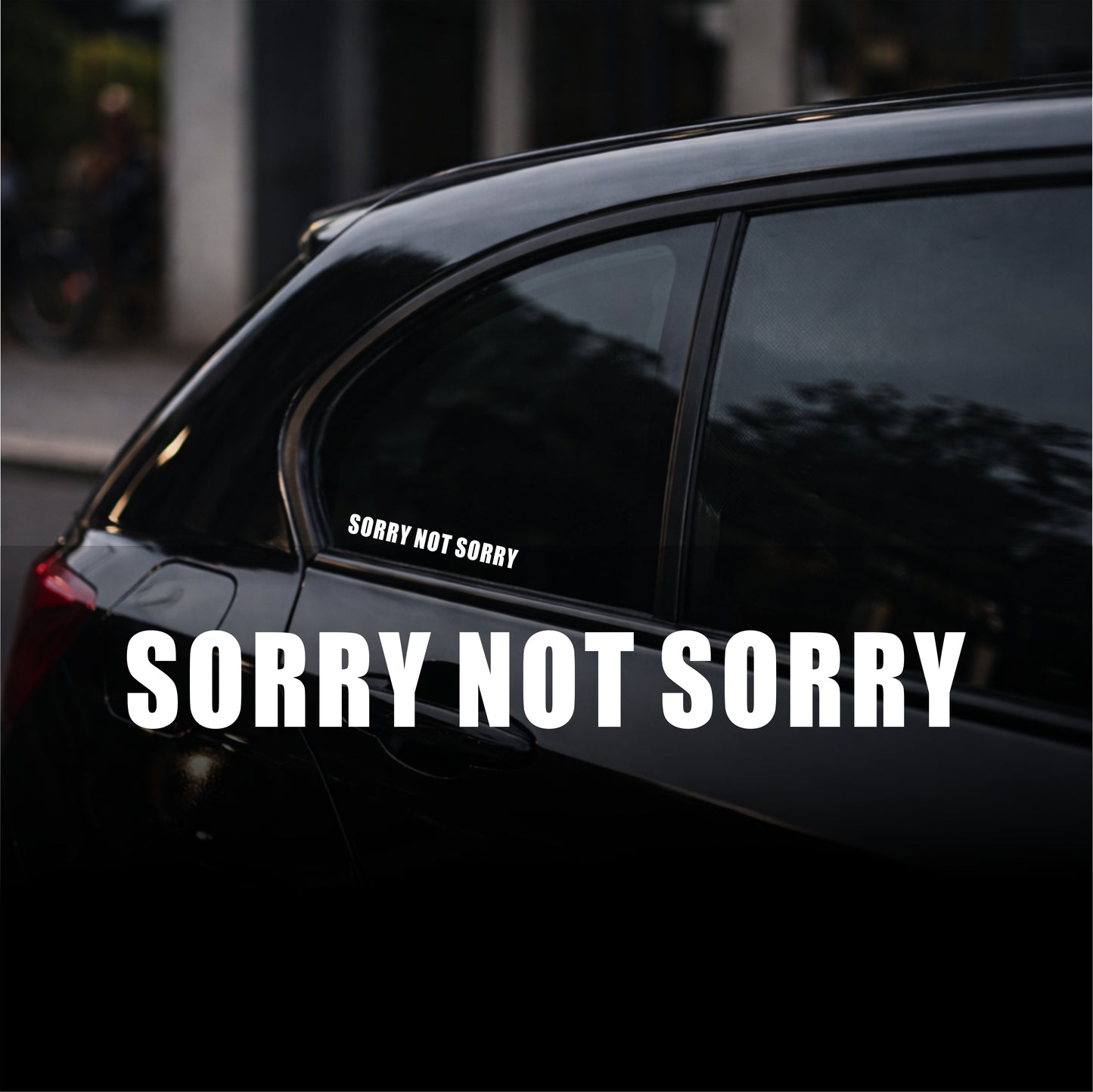 Car with 'Sorry Not Sorry' decal on a dark background