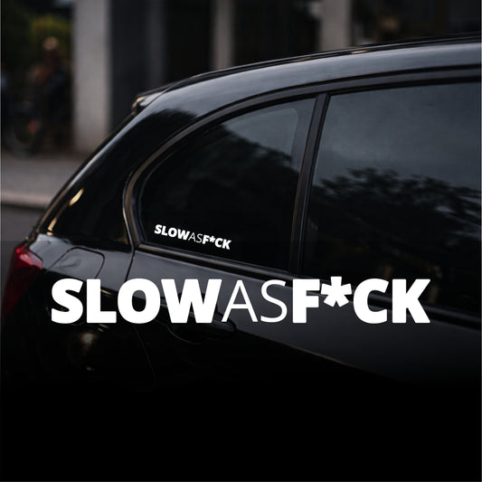 Black car with 'SLOWASF*CK' decal on a blurred street background