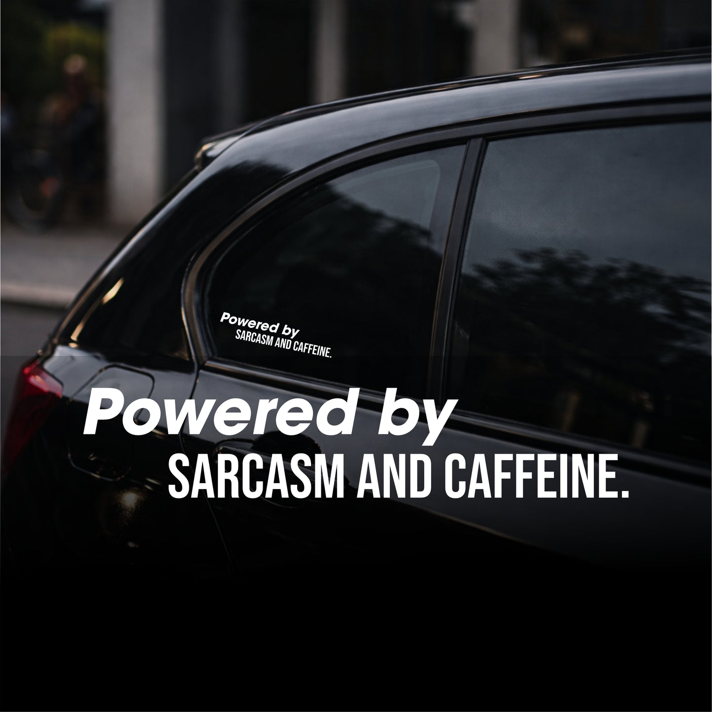 Black car with a decal reading 'Powered by Sarcasm and Caffeine' on a blurred street background.