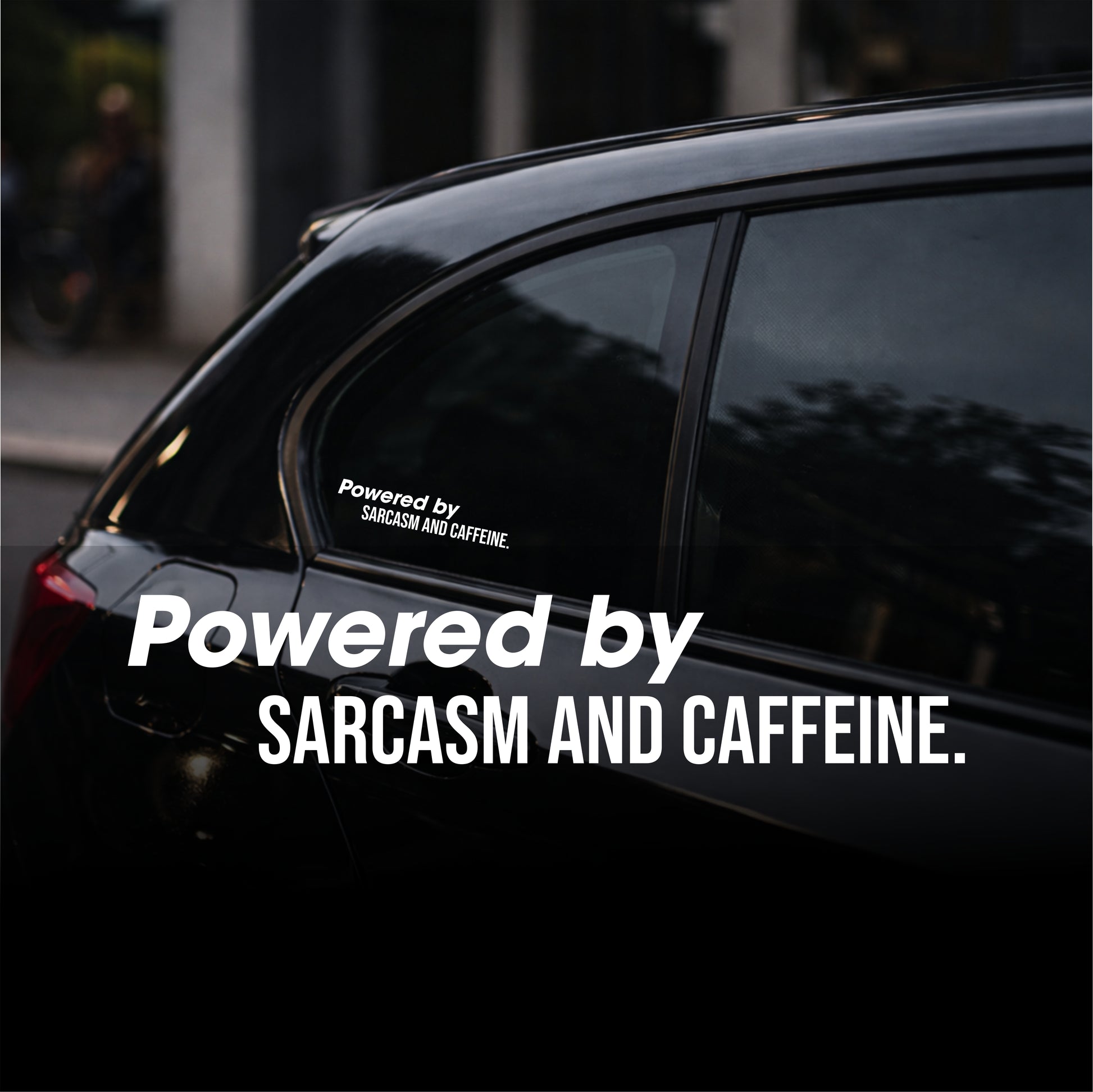 Black car with a decal reading 'Powered by Sarcasm and Caffeine' on a blurred street background.