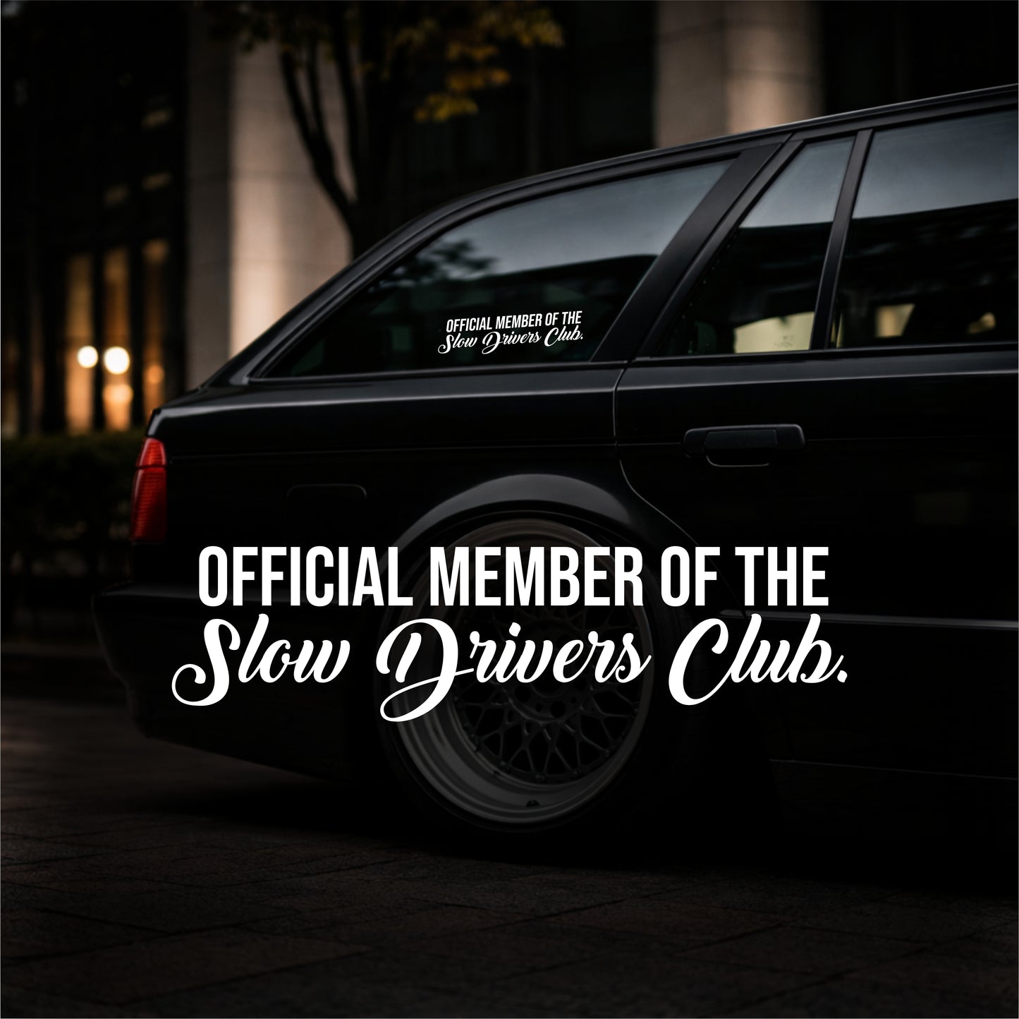 Black car with 'Official Member of the Slow Drivers Club' decal on a dark background