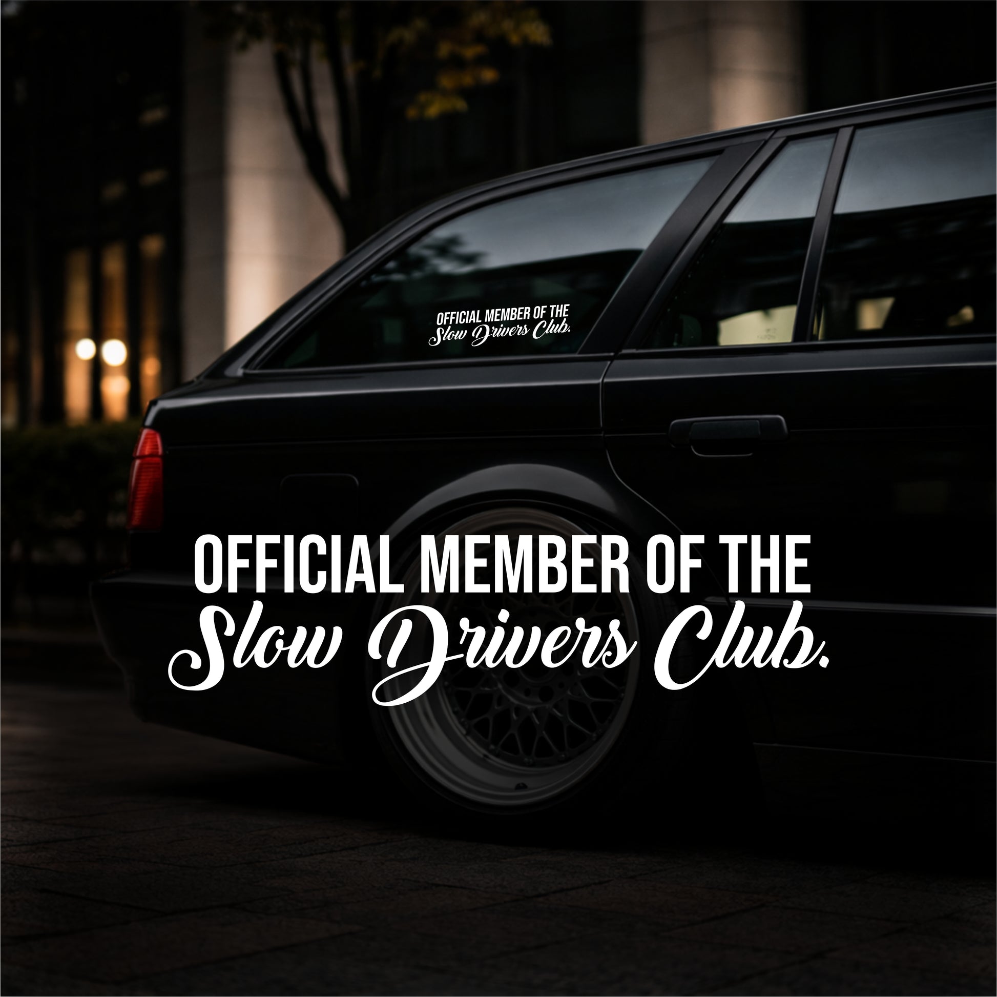 Black car with 'Official Member of the Slow Drivers Club' decal on a dark background
