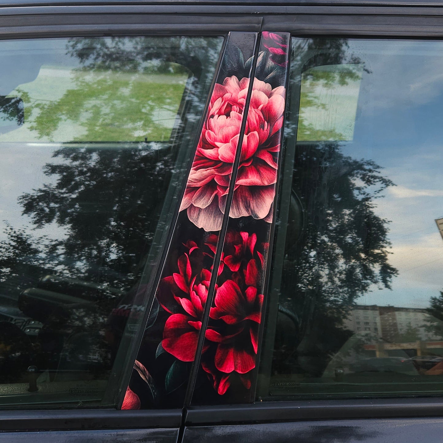 Car door with floral design reflection on a city street