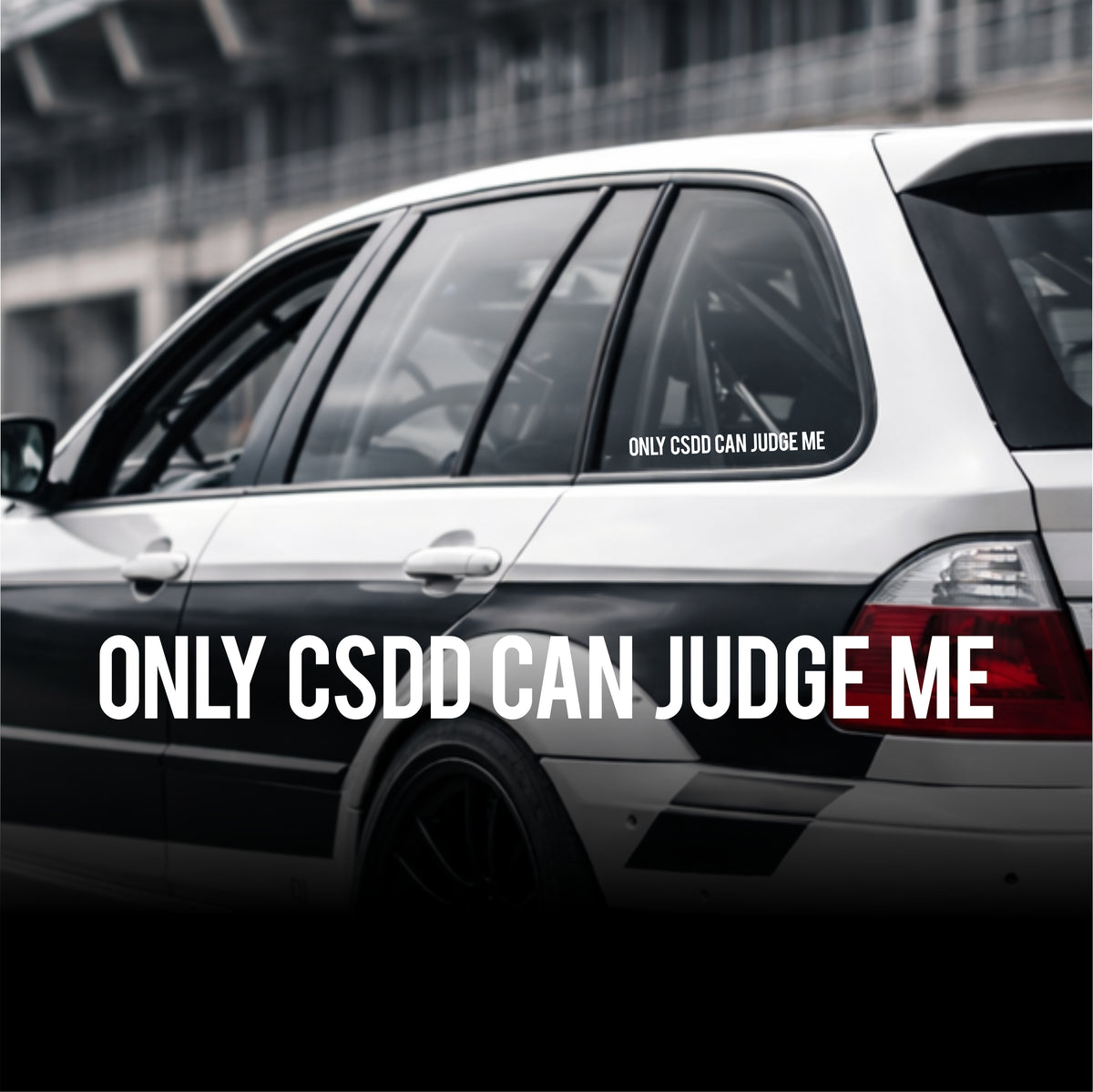 Car with 'ONLY CSDD CAN JUDGE ME' decal on a blurred background