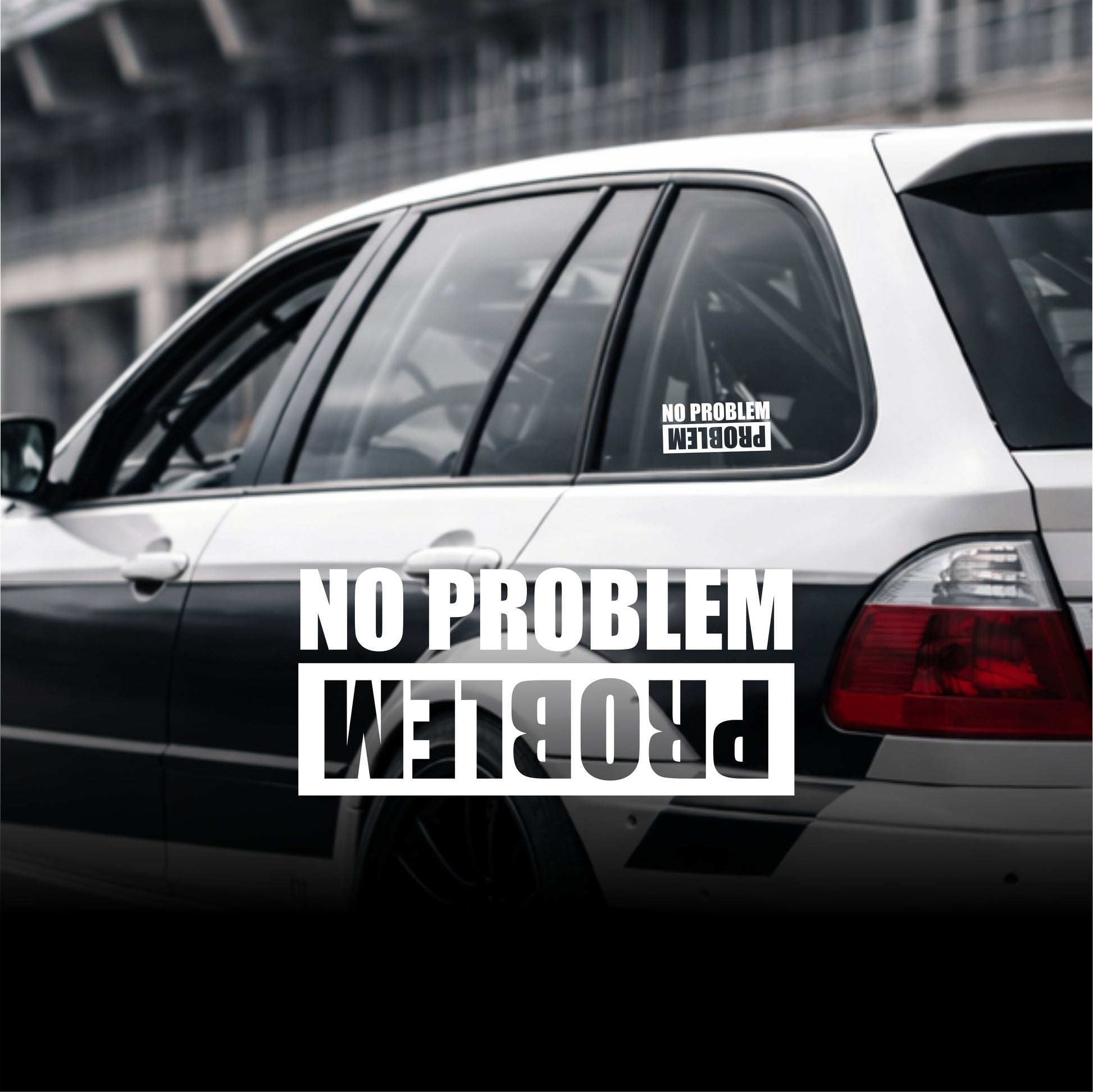 Car with 'No Problem' and 'Problem' decals on a blurred background