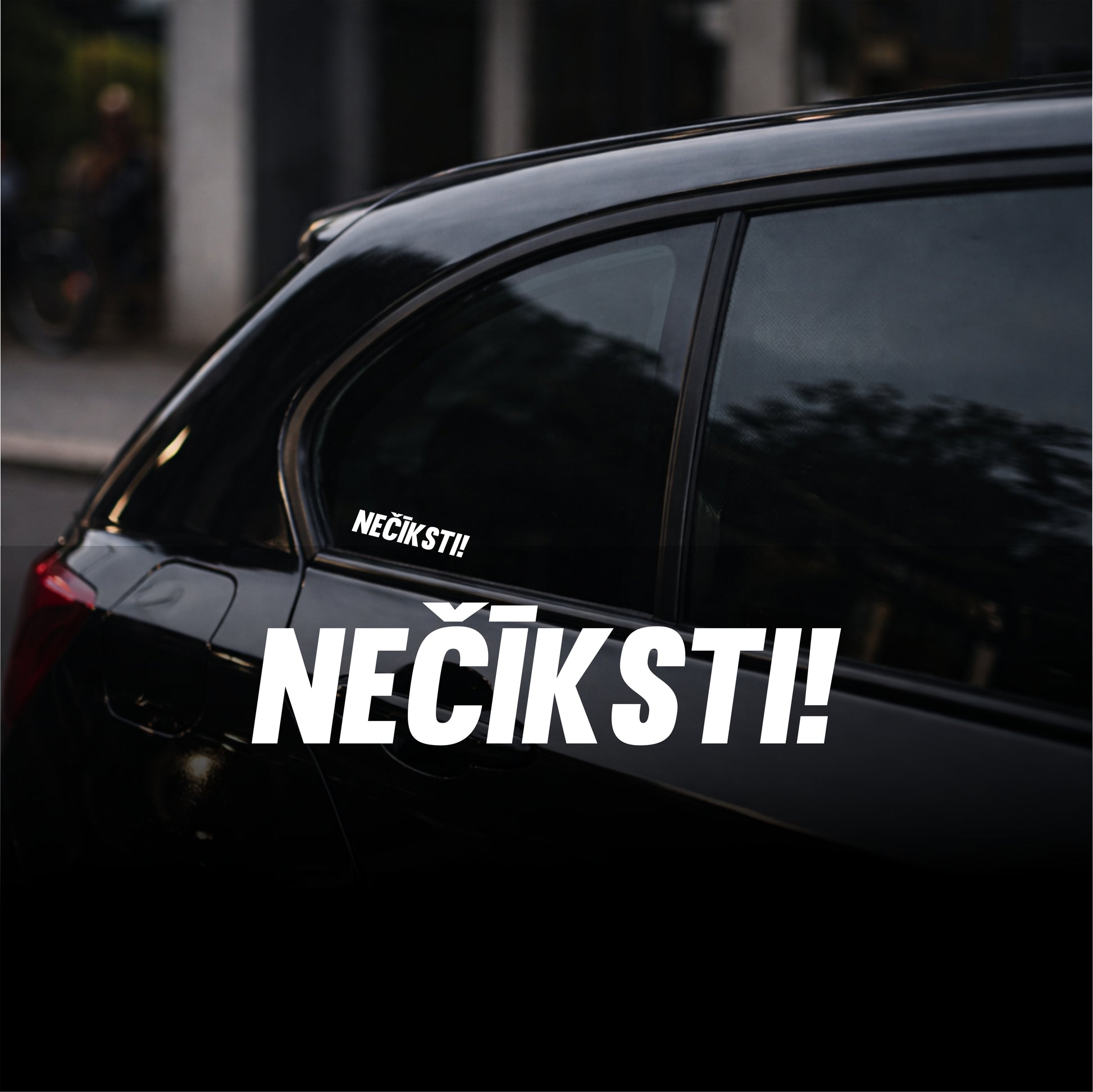 Black car with 'NEŇIKSTI!' sticker on a blurred street background