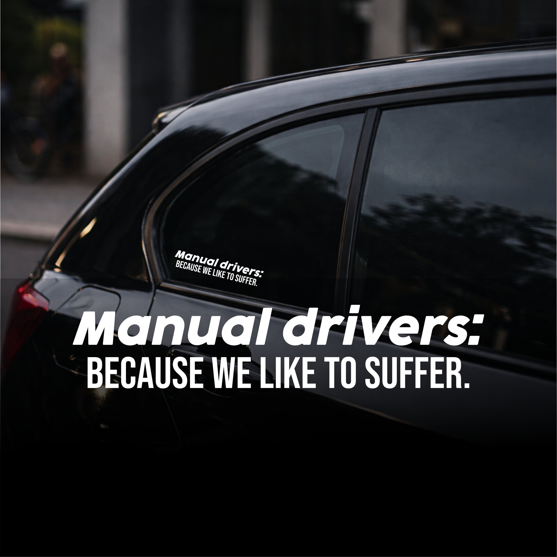 Car with a humorous sticker on the window, set against an urban background.