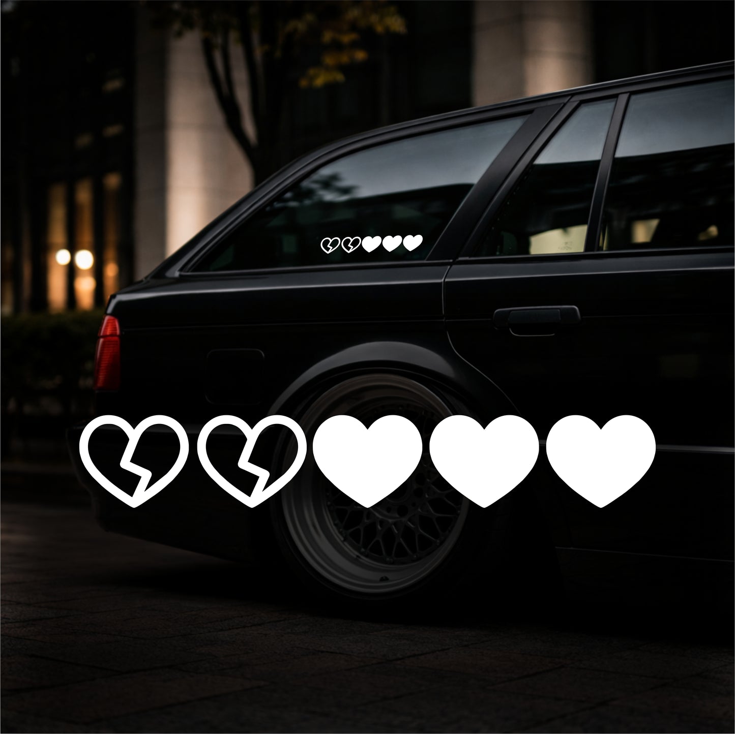 Black car with heart-shaped decals on a dark background