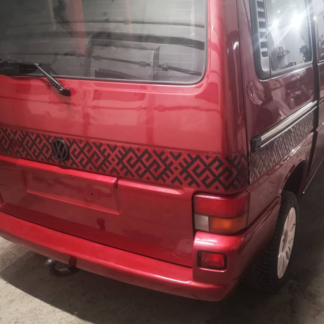 Red van parked on a concrete surface with visible branding.