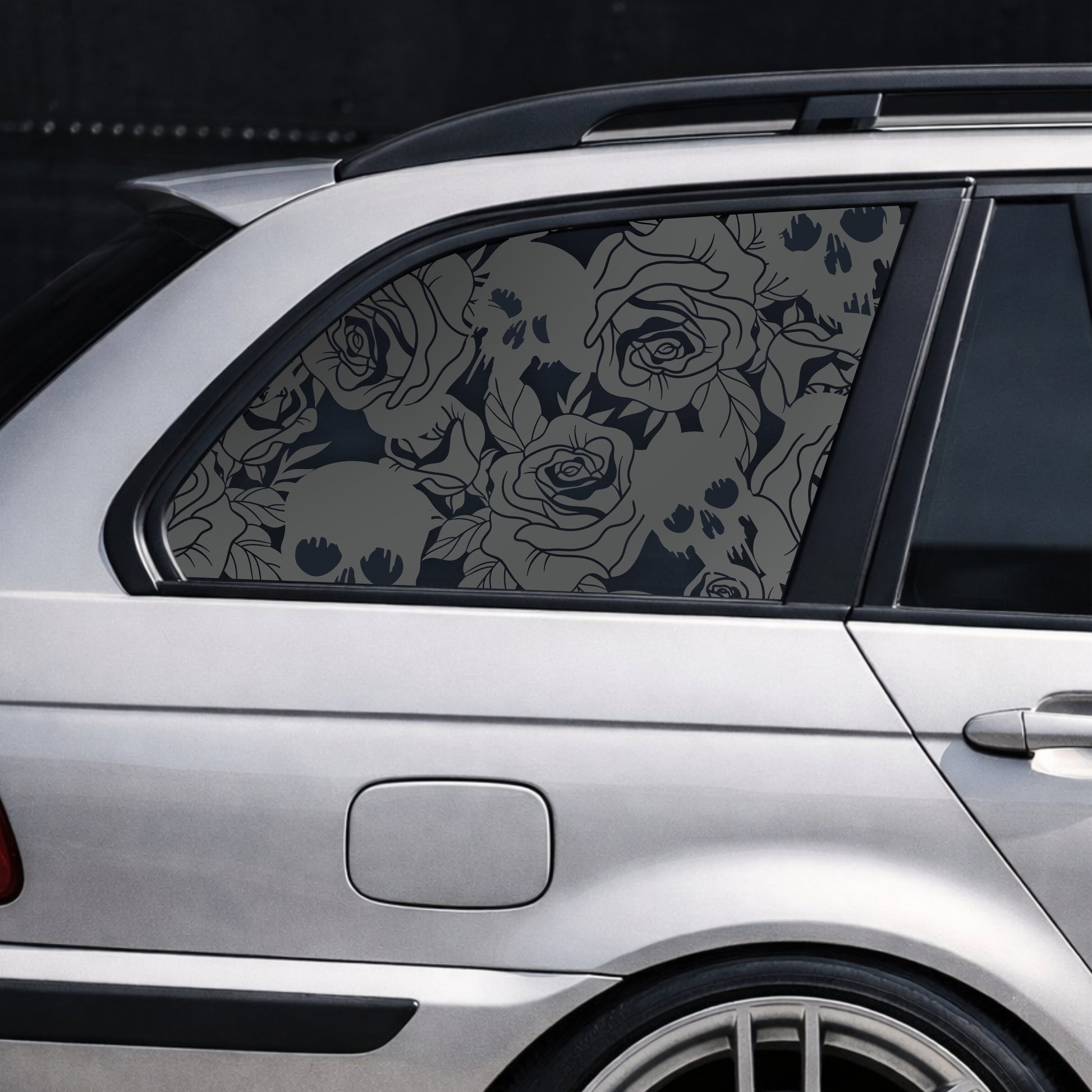 Car window with floral patterned film on a dark background