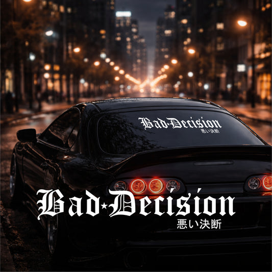 Car with 'Bad Decision' on the back window and license plate in an urban night setting.