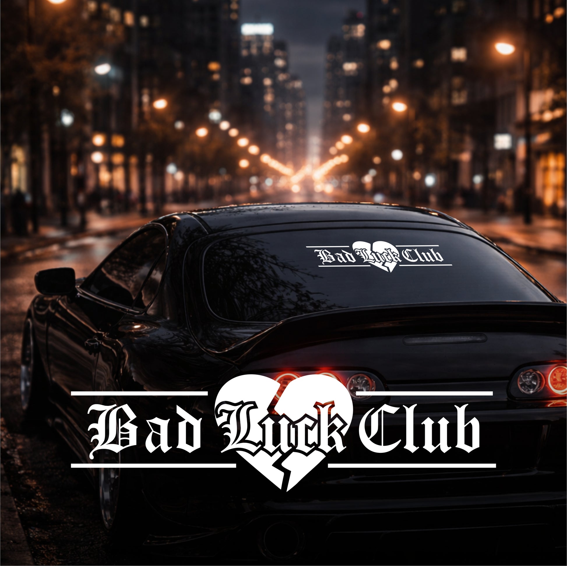 Car with 'Bad Luck Club' decal on a city street at night