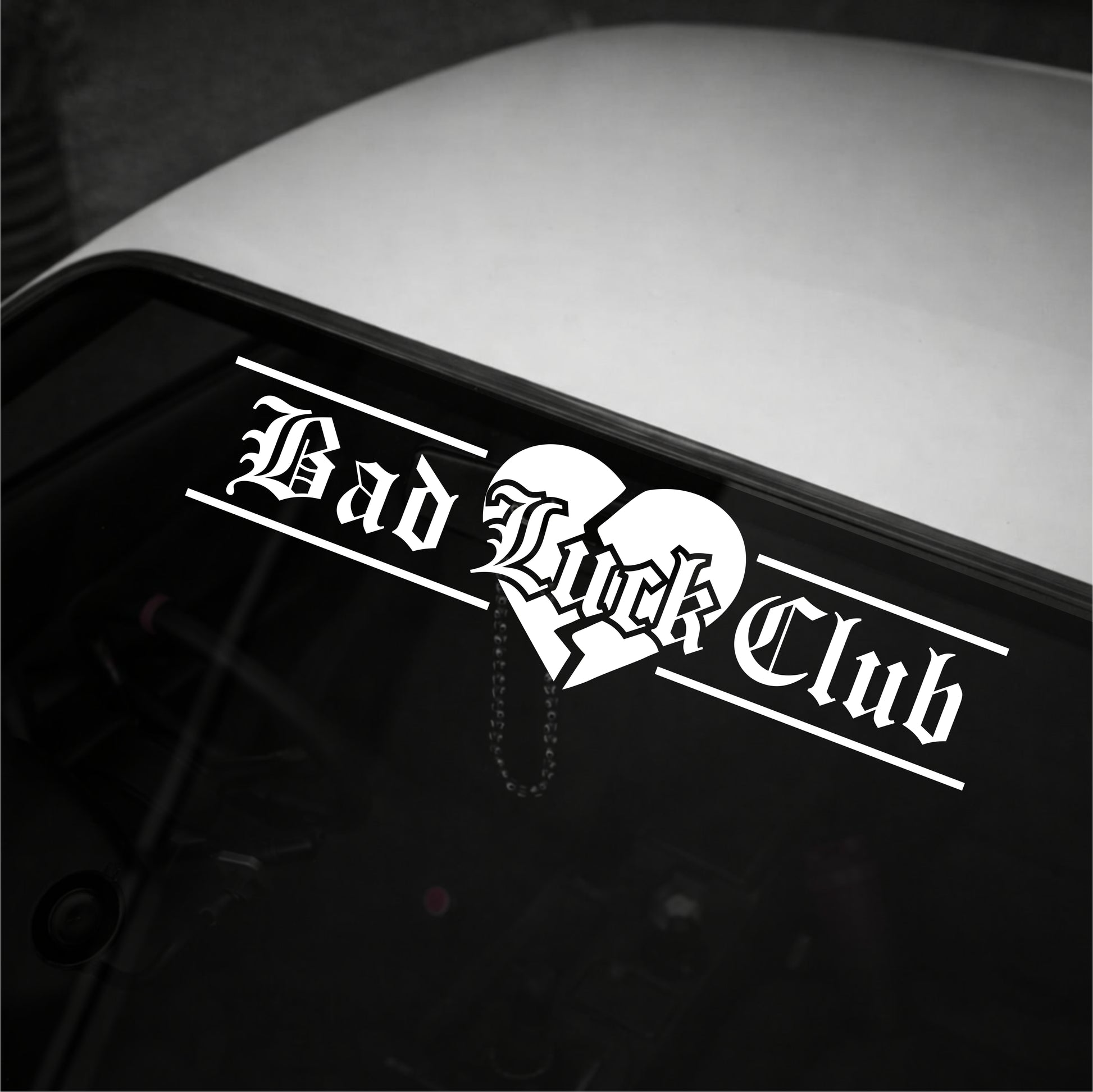 Sticker with 'Bad Luck Club' text on a vehicle's window