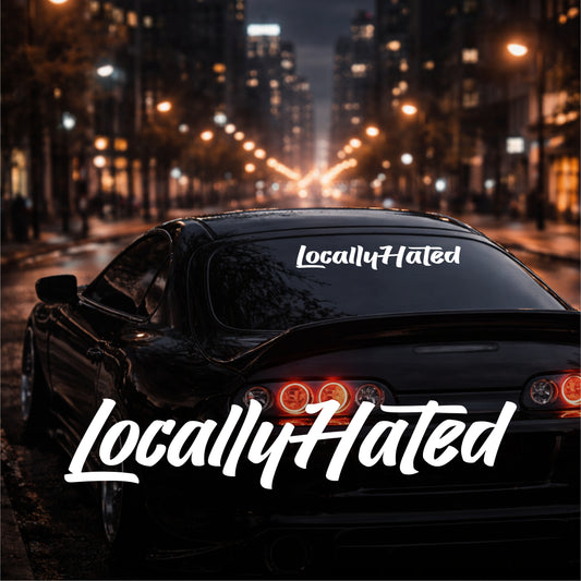 Car with 'LocallyHated' decal on a city street at night