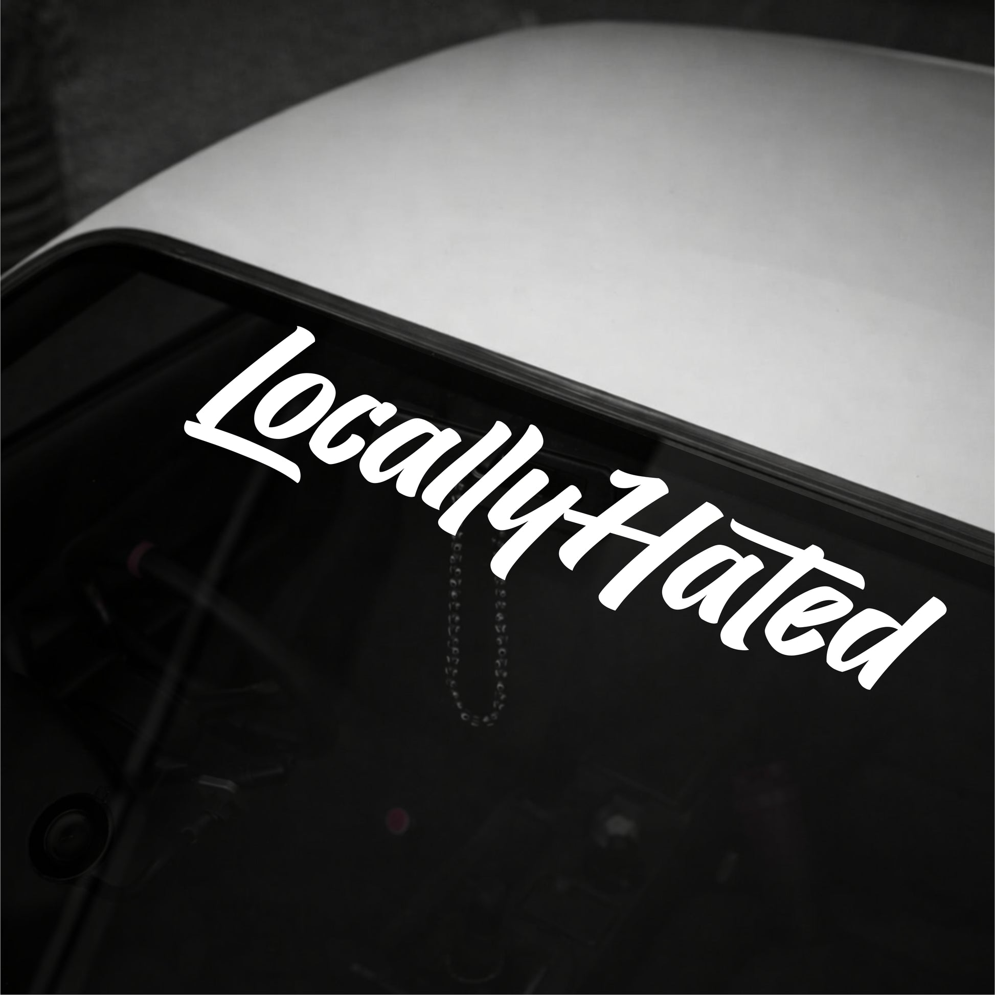 Car window with 'LocallyHated' decal in white text on a black background