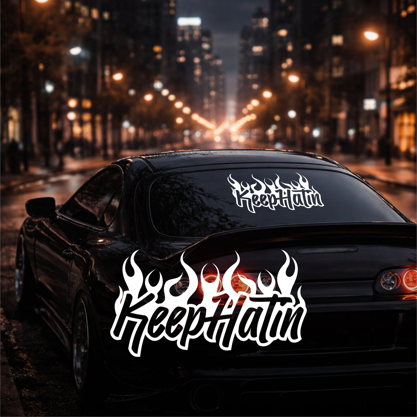 Car with 'KeepHatin' decals on a city street at night