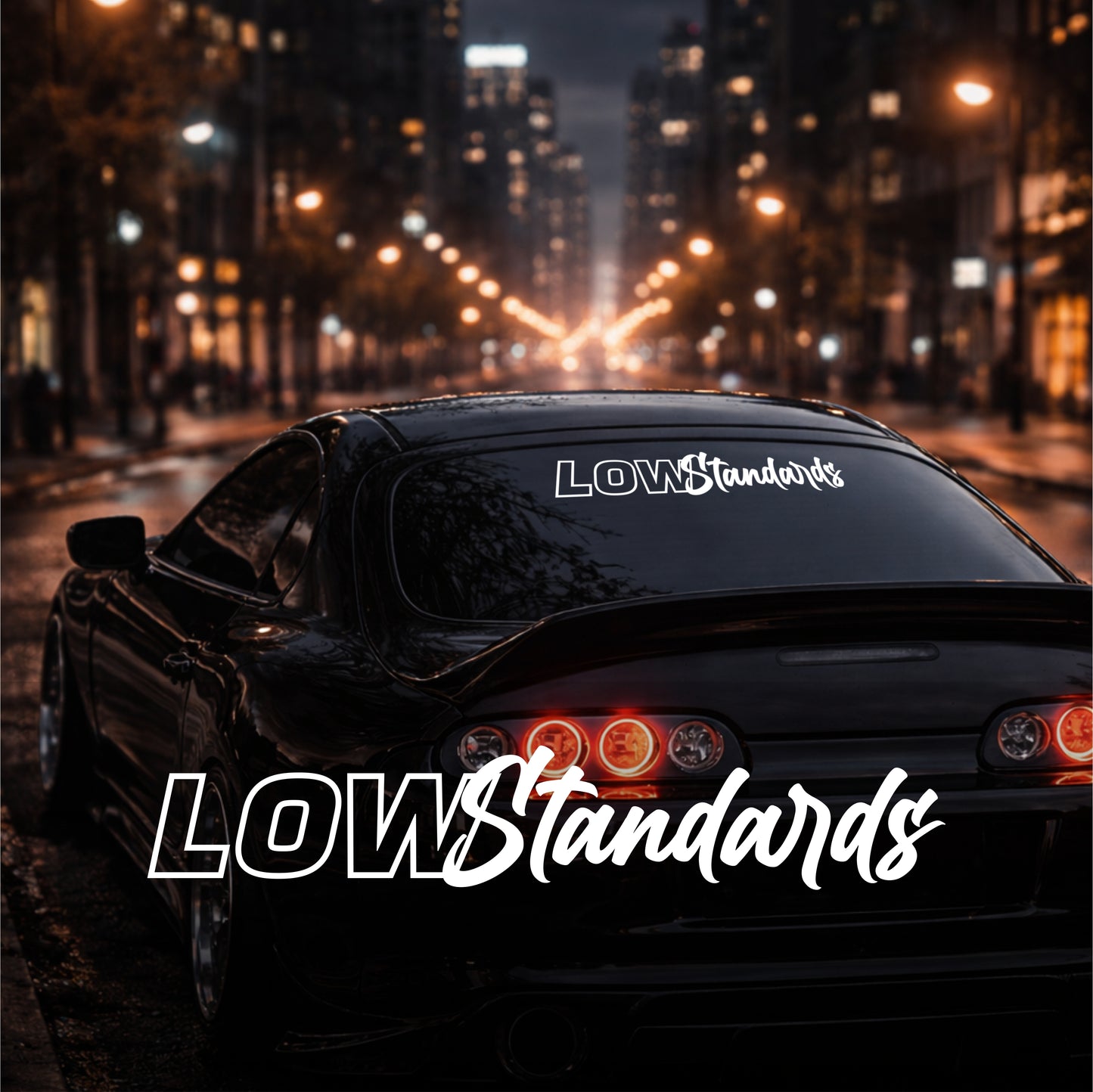 Car with 'LOW Standards' branding on a city street at night