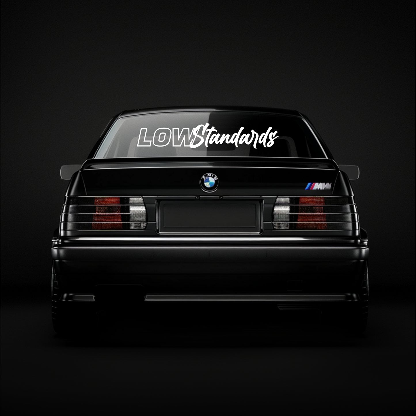 BMW car with 'LOW Standards' decal on a black background