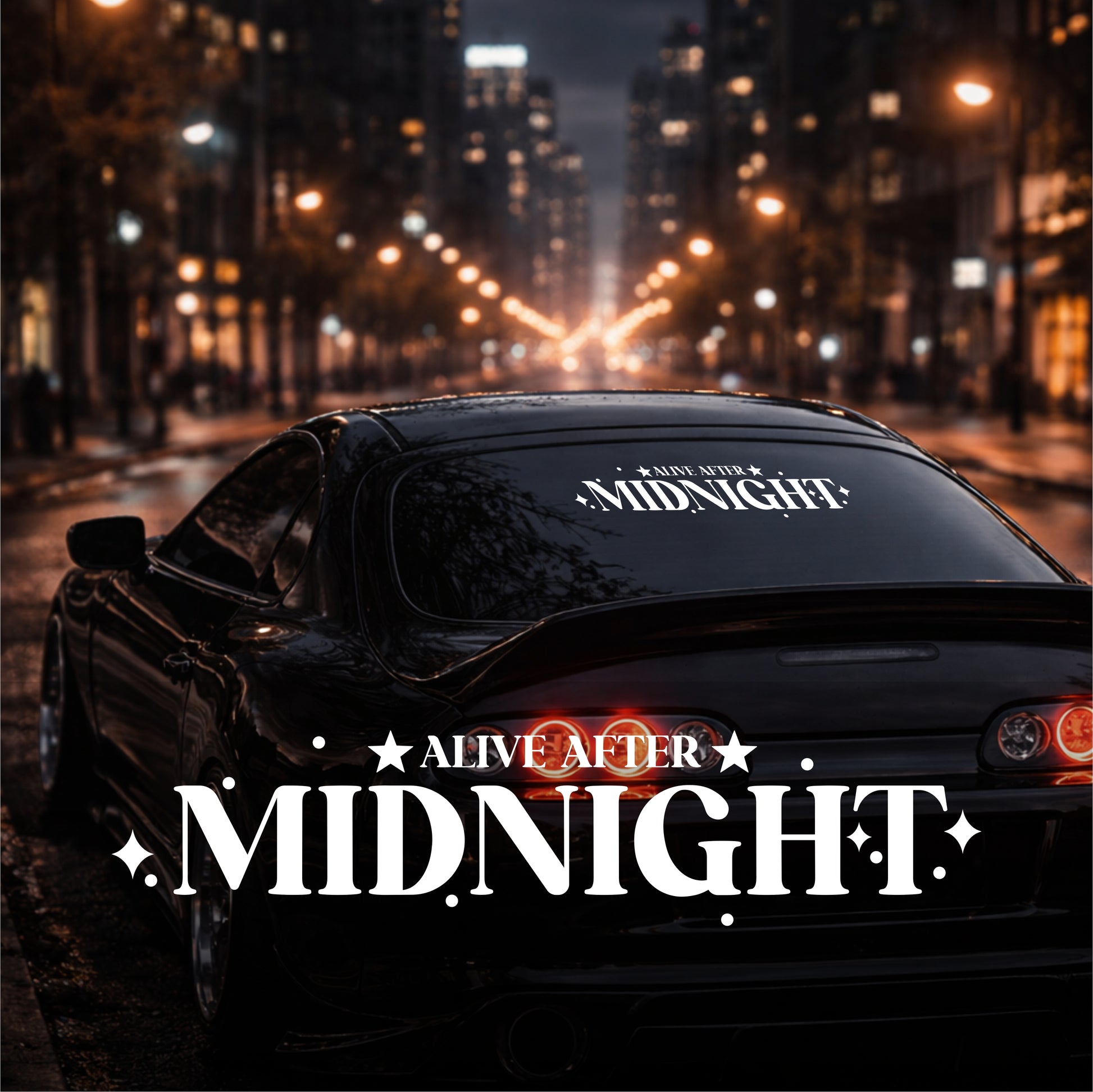 Car with 'Alive After Midnight' branding on a city street at night