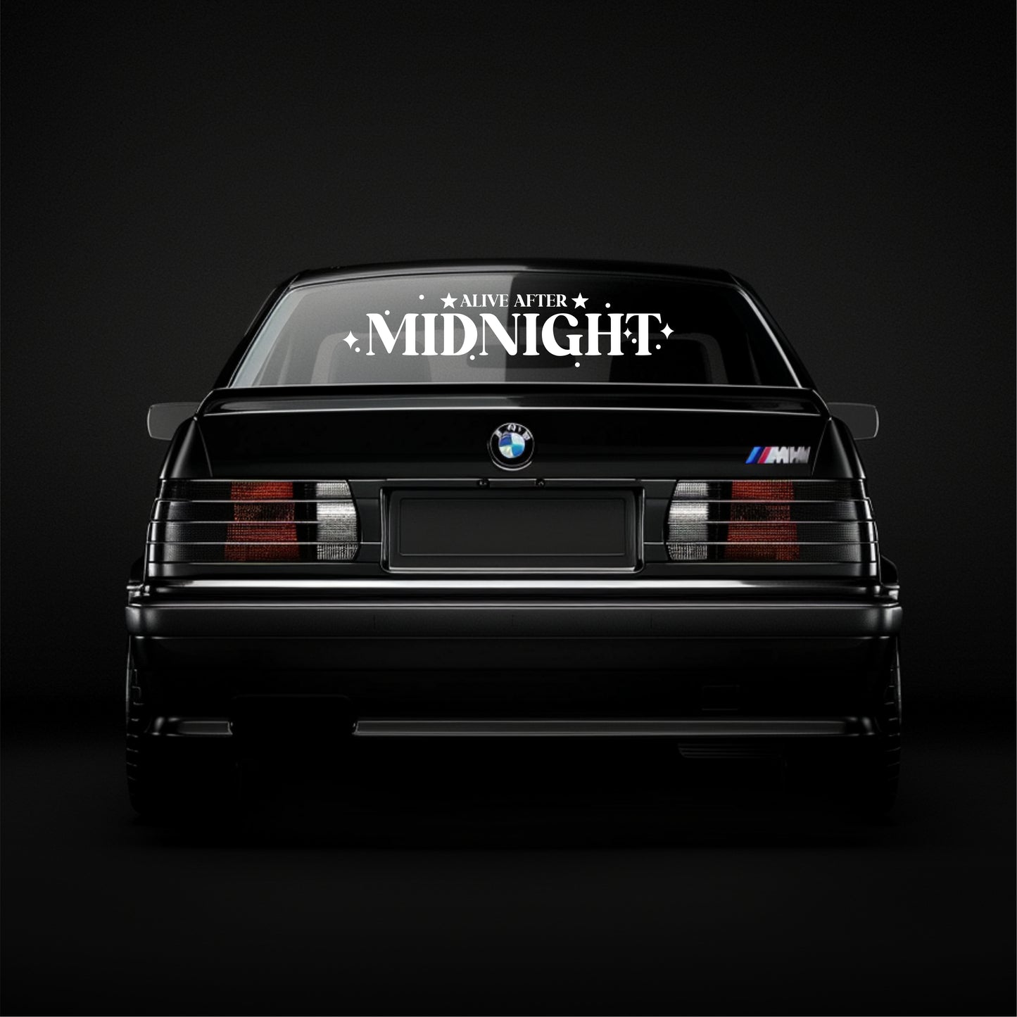 BMW car with 'Alive After Midnight' decal on a black background