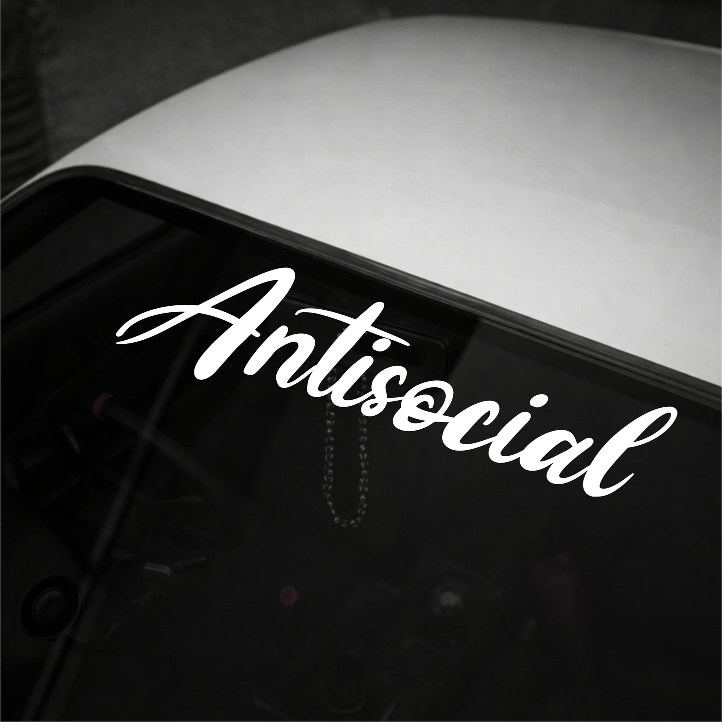 White 'Antisocial' decal on a car window