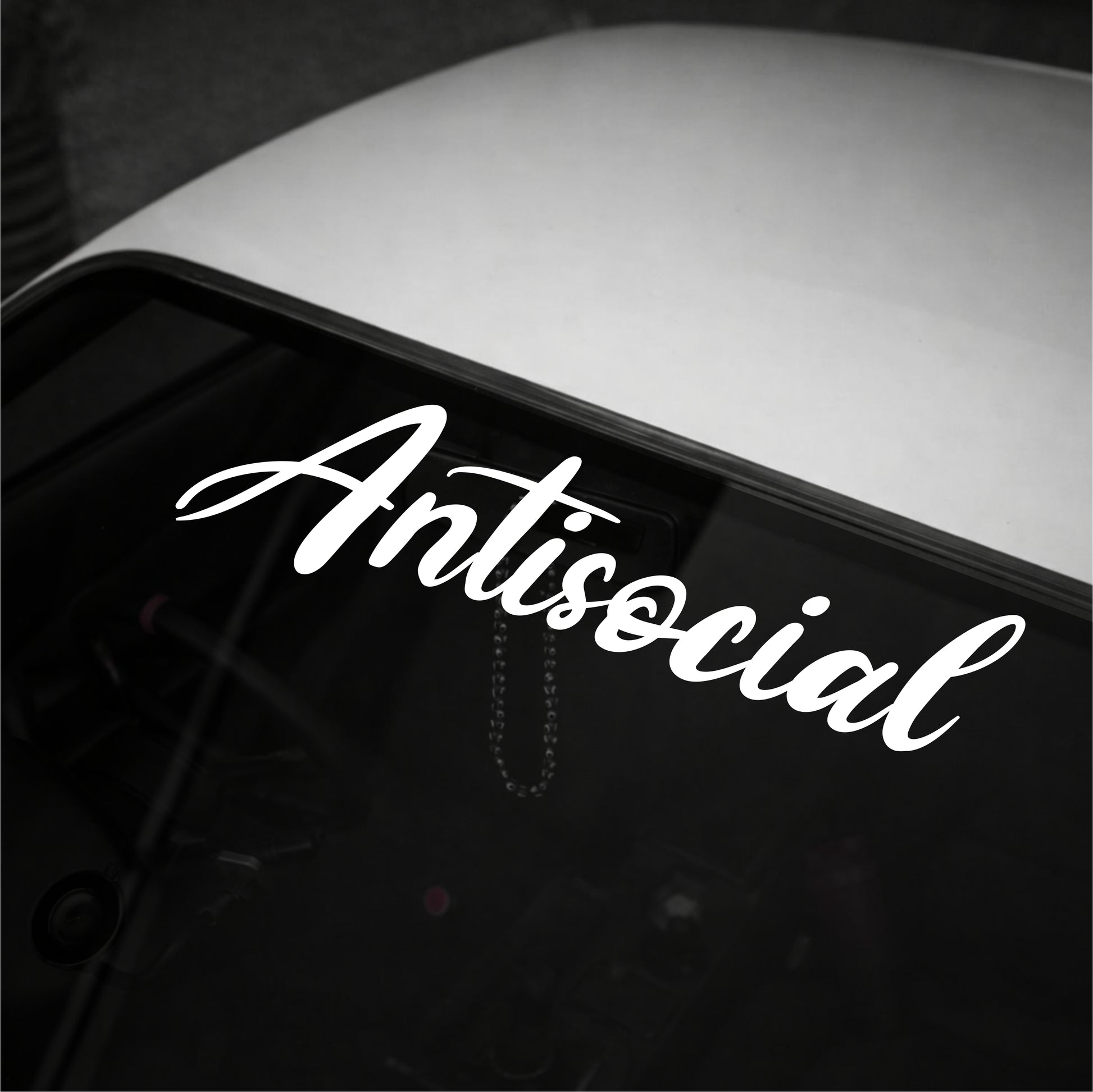 White 'Antisocial' decal on a car window