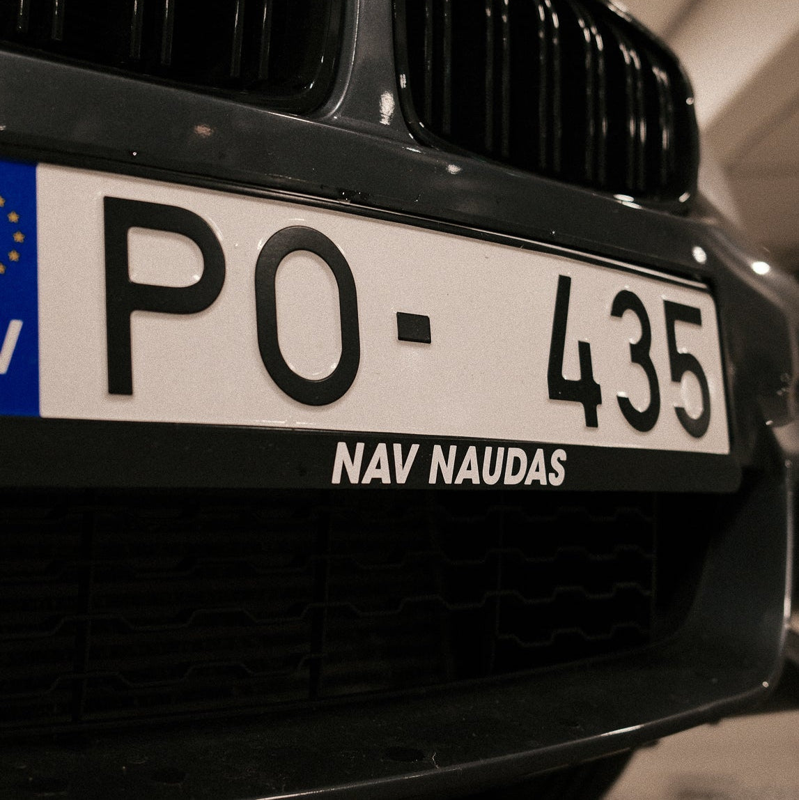 Close-up of a car license plate with 'PO-435' and 'NAV NAUDAS' text.
