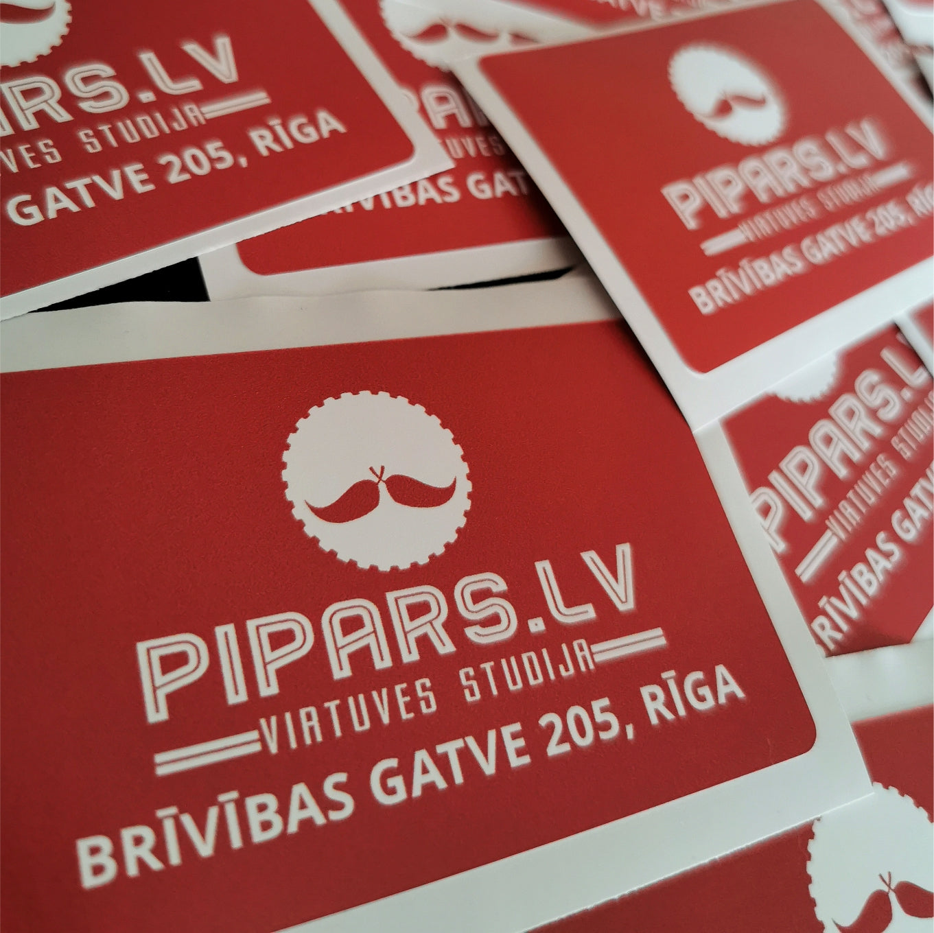 Red stickers with 'PIPARS.LV' branding on a white background