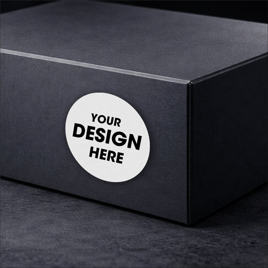 Black box with a round white sticker that says 'Your Design Here' on a dark background