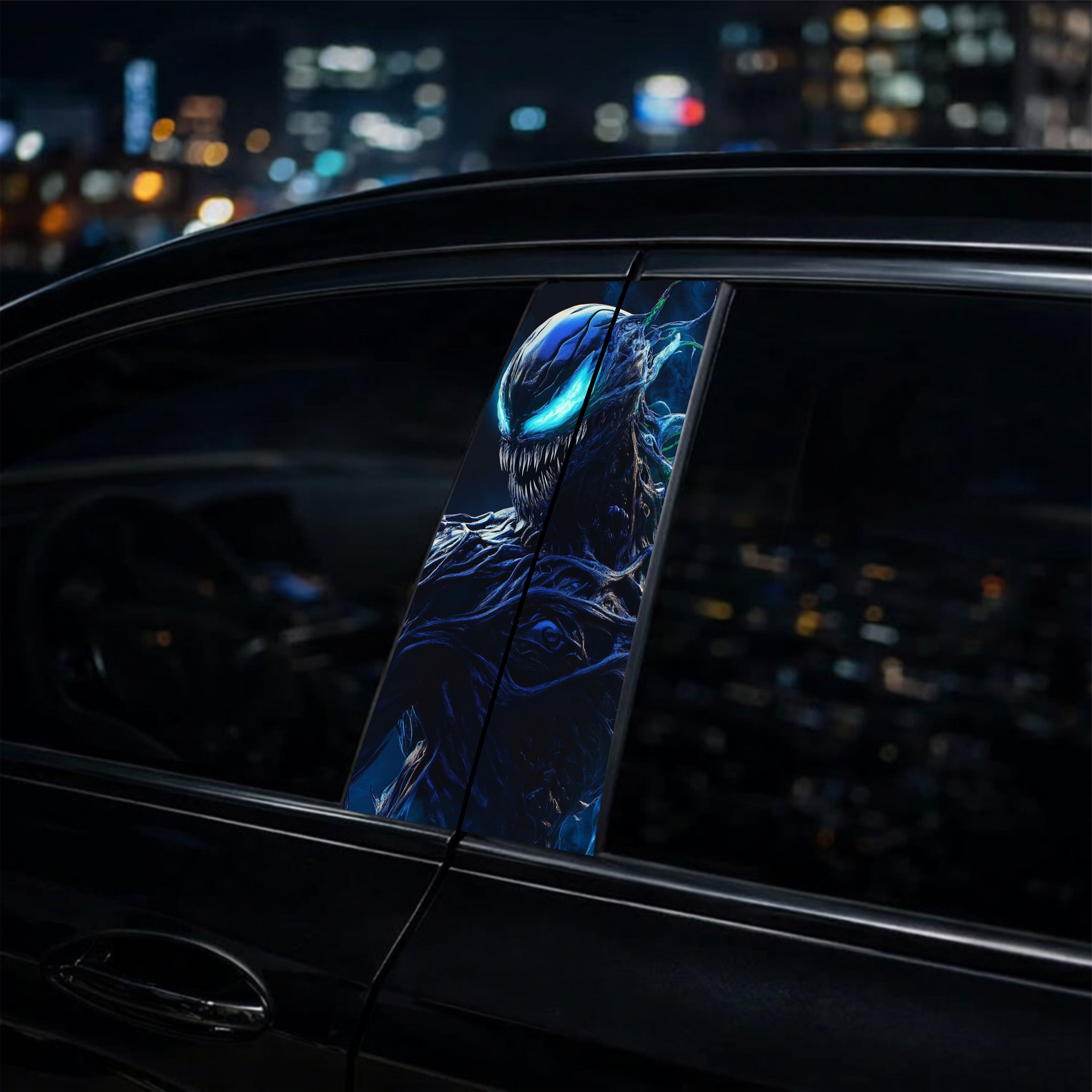 Phone case with a blue and black design of a creature, held against a car window at night.