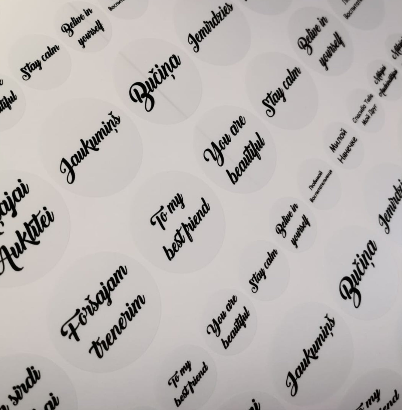 Sheet of adhesive stickers with various motivational phrases on a white background